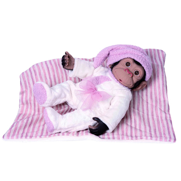 Mono reborn de Rosatoys 3351 de 35 cm tumbado con pijama blanco de peluche, gorro de dormir rosa y manta a rayas
