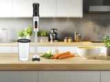 Batidora FLAMA 2063FL con vaso medidor en una cocina, junto a verduras y crema de calabaza