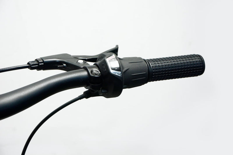 Detalle del sistema de cambios Shimano de 7 velocidades de la bicicleta UMIT XR-240 roja, con manetas ergonómicas y transmisión precisa para adaptarse a cualquier terreno
