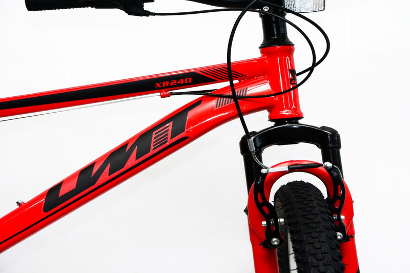 Detalle de la horquilla de suspensión delantera de la bicicleta UMIT XR-240 roja, que absorbe impactos y vibraciones para mayor confort y control en terrenos irregulares
