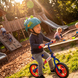 Niño en bici sin pedales con el casco Moltó Dino 26250 puesto