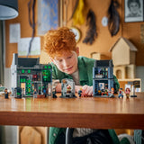 Niño pelirrojo jugando con el set LEGO Harry Potter 76471 Callejón Knockturn ya montado en mesa de madera, con minifiguras alineadas y los dos edificios Potages y Borgin & Burkes