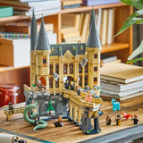 Set LEGO Harry Potter 76473 Castillo Hogwarts Ala Este expuesto sobre escritorio de madera con sus minifiguras alineadas - decoración coleccionista del Wizarding World