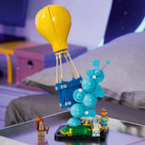 Set LEGO Fortnite 77080 Supply Drop expuesto sobre mesa con dormitorio juvenil de fondo - globo amarillo, canasta de suministros azul, minifigs Fishstick, Astro Jack y Gingerbread