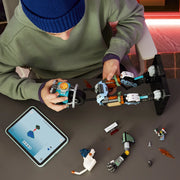 Niño con gorro azul construyendo el mecha LEGO Fortnite 77081 KIT vista cenital - tableta LEGO Builder, brazo del mecha en proceso y partes del torso azul