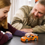 Padre con barba y niña jugando con el coche LEGO Speed Champions 77260 Toyota Supra MK4 Fast & Furious ya montado sobre mesa - colección Fast & Furious