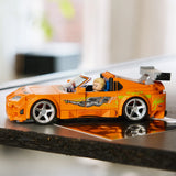 LEGO Speed Champions 77260 Toyota Supra MK4 Fast & Furious vista lateral con perfil del coche naranja expuesto sobre superficie reflectante - colección automoción