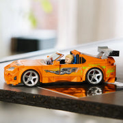 LEGO Speed Champions 77260 Toyota Supra MK4 Fast & Furious vista lateral con perfil del coche naranja expuesto sobre superficie reflectante - colección automoción
