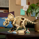 Set LEGO Jurassic World 77985 Triceratops Fósiles montado expuesto sobre mesa de madera redonda en salón - decoración coleccionista adulta con placa Jurassic Park y minifigura paleontólogo