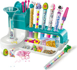 Contenido del kit Clementoni Laboratorio de Bolígrafos mostrando cuerpos de bolígrafos, cartuchos de tinta, pegatinas decorativas, purpurina y accesorios creativos
