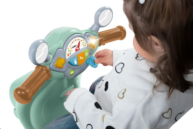 Detalle del panel electrónico interactivo de la Vespa Primavera Chicco con llave de contacto, botones sonoros, luces de colores y depósito de gasolina funcional
