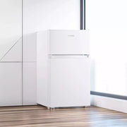 Frigorífico Infiniton FG-85D8WEH blanco colocado junto a la ventana de una cocina