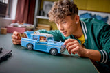 Joven construyendo LEGO Harry Potter 76470 Ford Anglia azul turquesa con Ron y Harry en interior
