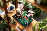 LEGO Jardín Meditativo 10315 montado en estantería con pabellón japonés, cerezos y puente rojo
