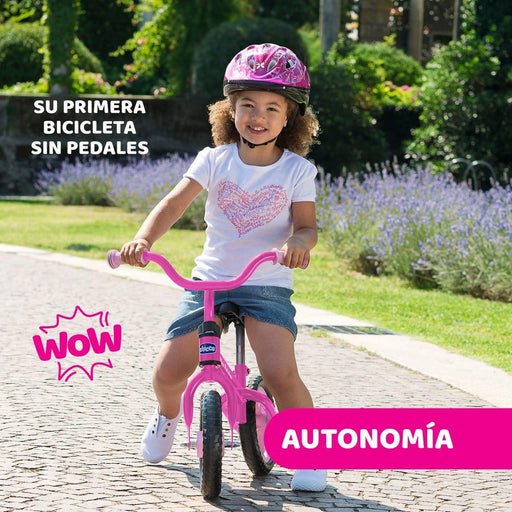 Niña pequeña montando la bicicleta de equilibrio Chicco First Bike rosa, impulsándose con los pies para desarrollar equilibrio y coordinación sin necesidad de ruedines
