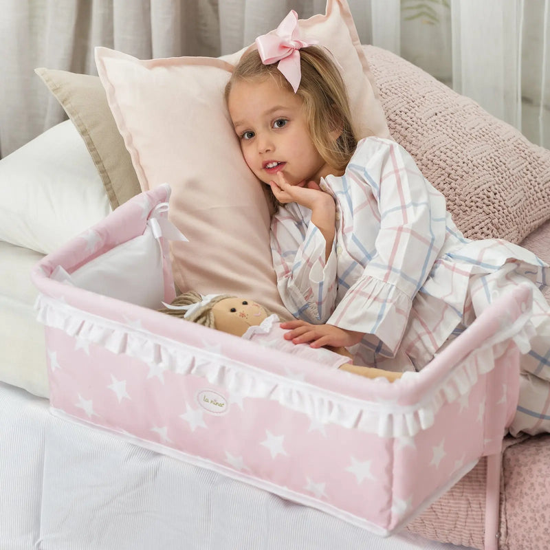Niña usando cuna colecho Carlota con muñeca en cama, vista completa
