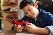 Niño jugando con LEGO Ferrari SF90 XX Stradale 77254 coche rojo deportivo
