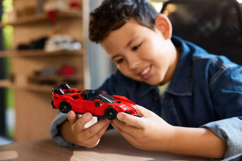 Niño jugando con LEGO Ferrari SF90 XX Stradale 77254 coche rojo deportivo
