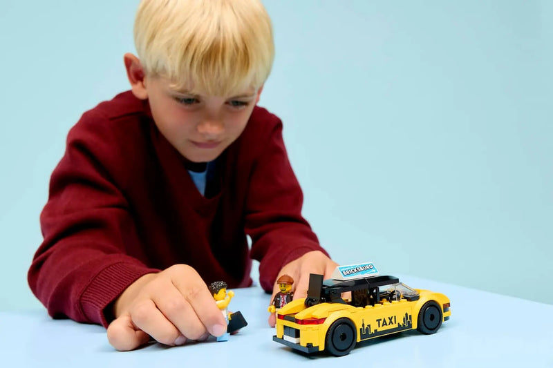 Niño jugando con Taxi Amarillo LEGO City 60487 minifiguras taxista y turista
