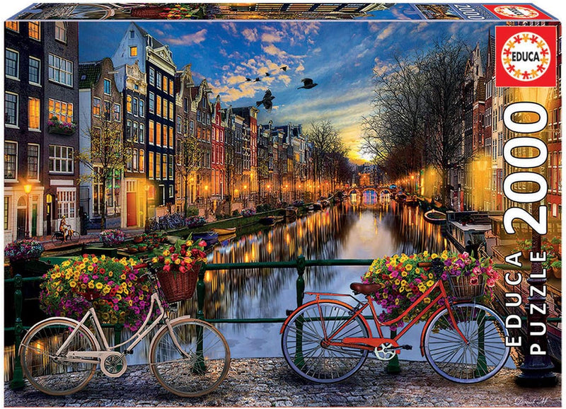 Puzzle Educa Borrás 17127 de 2000 piezas con imagen de Amsterdam mostrando canales históricos, casas típicas holandesas, puentes de piedra y bicicletas, ideal para amantes de Holanda y ciudades europeas

