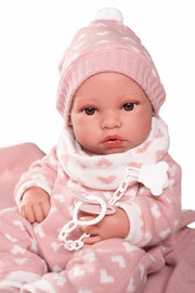 Recién nacida con gorro y manta rosa
