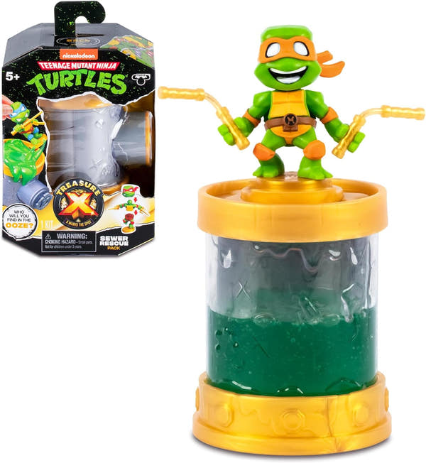 TX Sewer Conector Tortugas Ninja Treasure X con packaging original mostrando Michelangelo en tubería de alcantarillado dorada con líquido verde mutante
