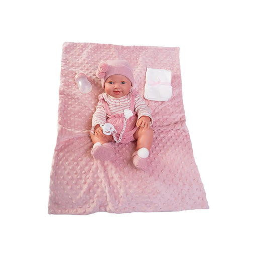 Vista desde arriba de Mía hace pipí acostada en su manta rosa con accesorios incluidos
