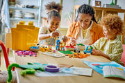 Niños y adulto jugando con las piezas del LEGO Classic 10698, con edificios y vehículos construidos