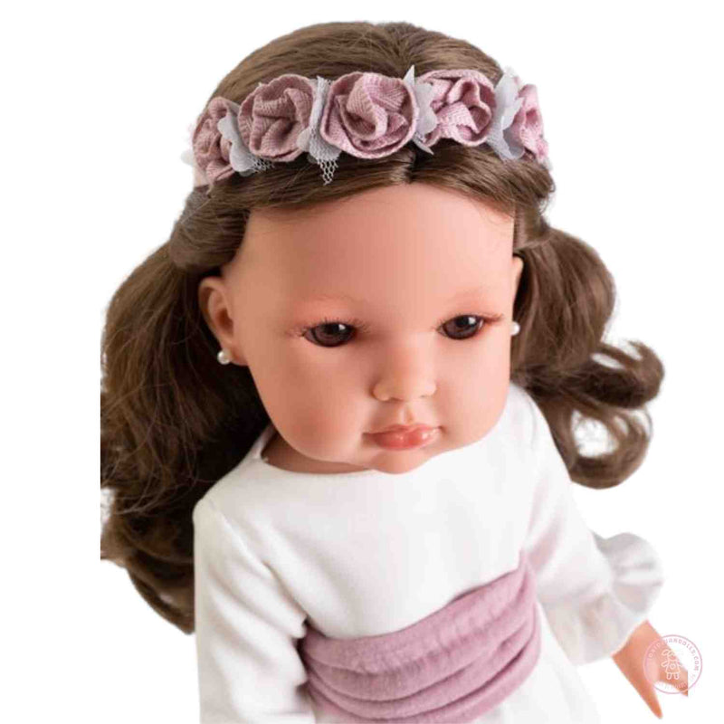 detalle del rostro de la muñeca bella comunión morena con diadema de flores
