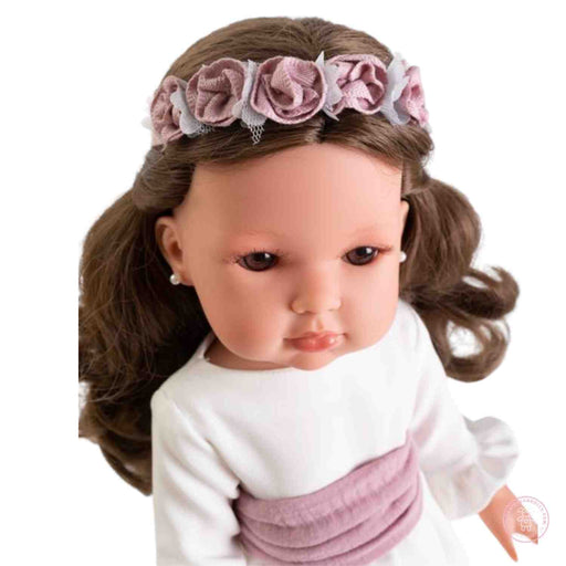 detalle del rostro de la muñeca bella comunión morena con diadema de flores
