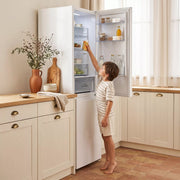 Niño abriendo el frigorífico combi Infiniton FGC-852C85WDK blanco en una cocina luminosa