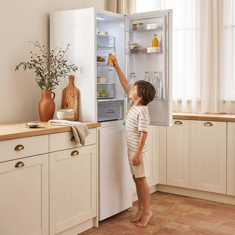 Niño abriendo el frigorífico combi Infiniton FGC-852C85WDK blanco en una cocina luminosa