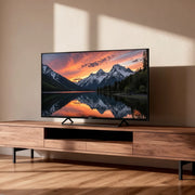 Televisor Genium GTV65QLED de 65 pulgadas colocado en un mueble de salón