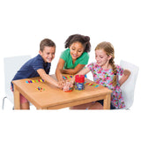 Tres niños jugando al Colorline Cayro 332 en una mesa, pulsando la campana