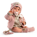 Antonio Juan Recién Nacida Pipa Paseo doll sitting in pink cardigan and hat, with dummy and teether