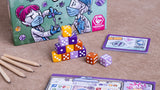 Detalle de los dados de colores de Virus! Roll & Write junto a la caja y una hoja de juego