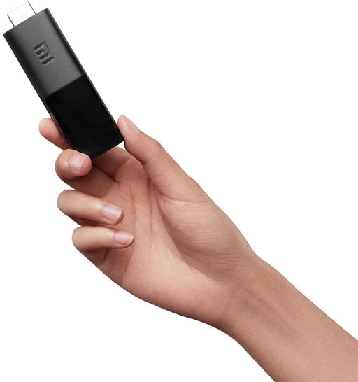 Xiaomi Mi TV Stick conectado al puerto HDMI de un televisor mostrando la interfaz de Android TV con aplicaciones de streaming como Netflix y YouTube
