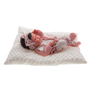 Muñeca Recién Nacida Pipa de Antonio Juan descansando en su suave cojín.
