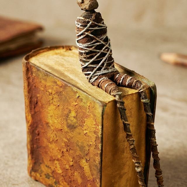 SENTADO SOBRE LIBRO, obra de Antonio Martínez Ruiz (Óxido)
