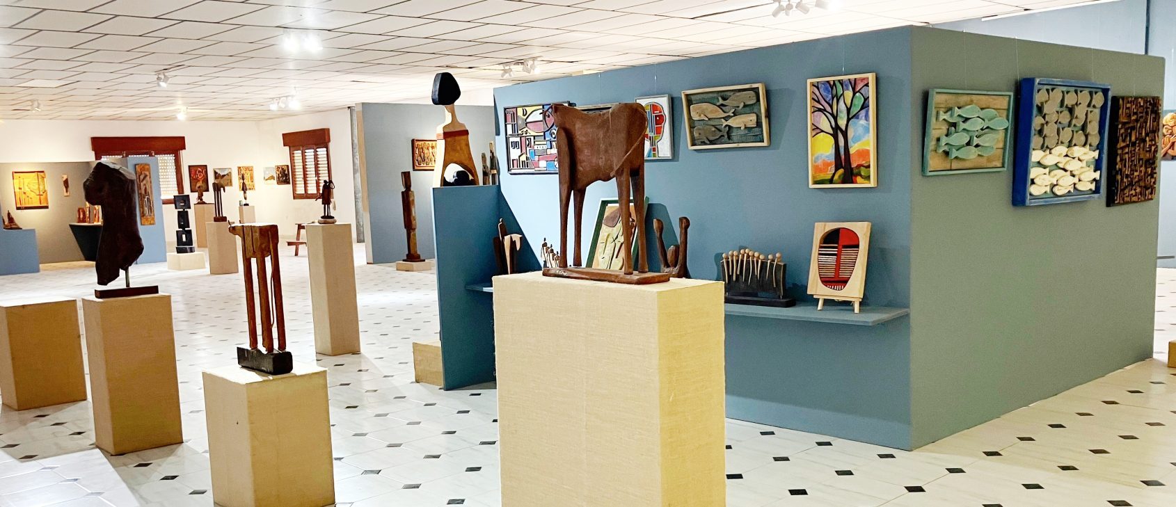 Paneles azules con tallas, relieves y figuras de óxido en la galería de Antonio Martínez Ruiz, en Albox