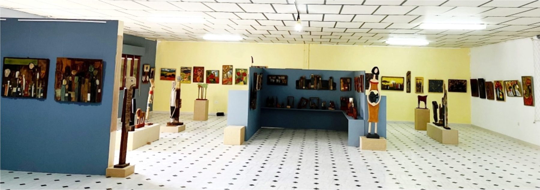 Vista general de la sala con esculturas y cuadros en las paredes