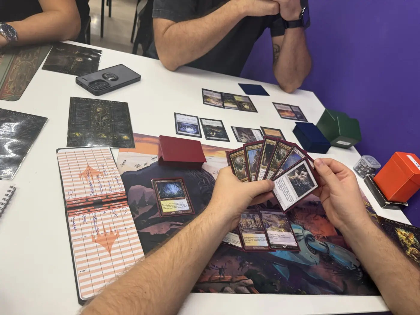 Un jugador abre su mano de cartas sobre el tapete, con la hoja de vidas al lado