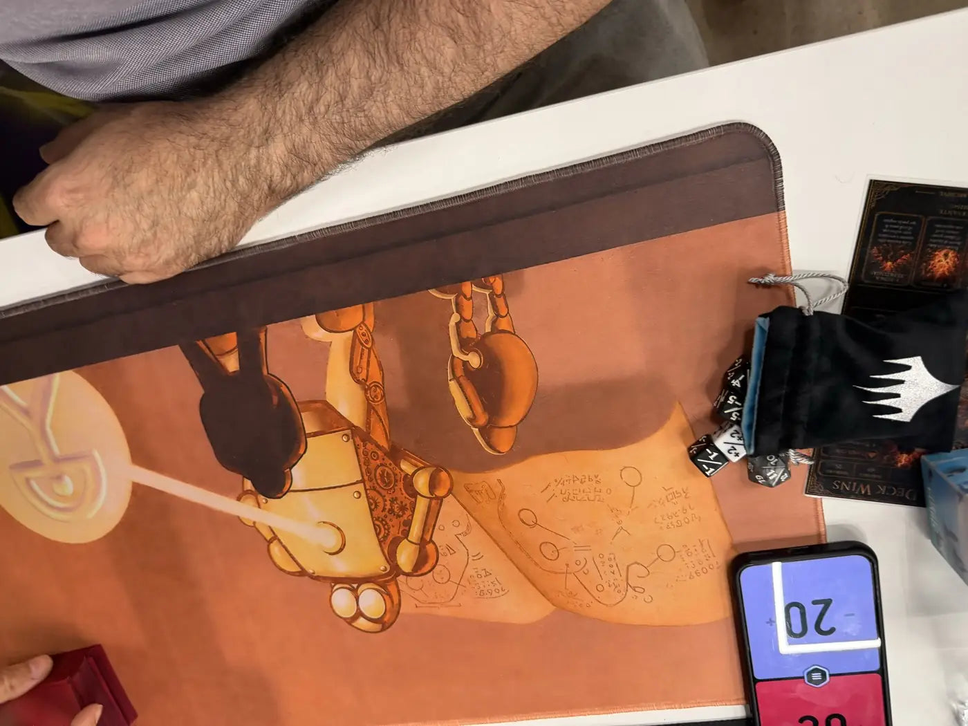 Detalle de un tapete con un autómata, la bolsa de dados y el contador de vidas a 20