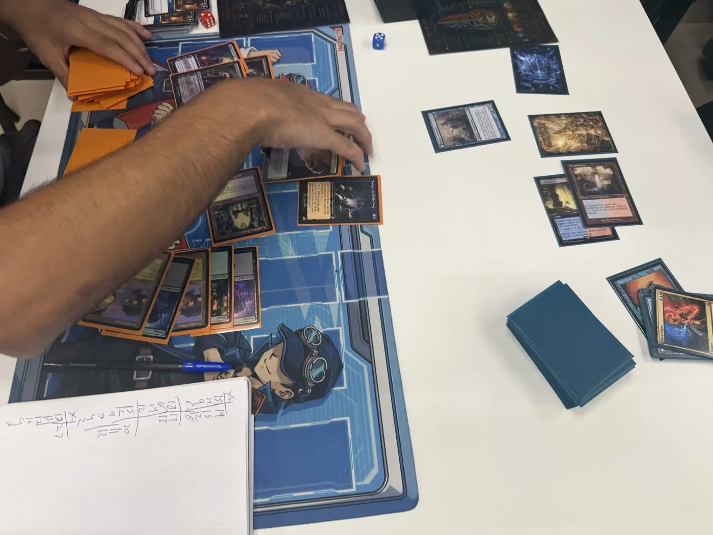 Un jugador coloca una carta sobre un tapete azul, con la hoja de vidas debajo